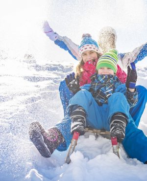 Family having fun in winter Happy family having fun together on the snowy mountain, on a sled.