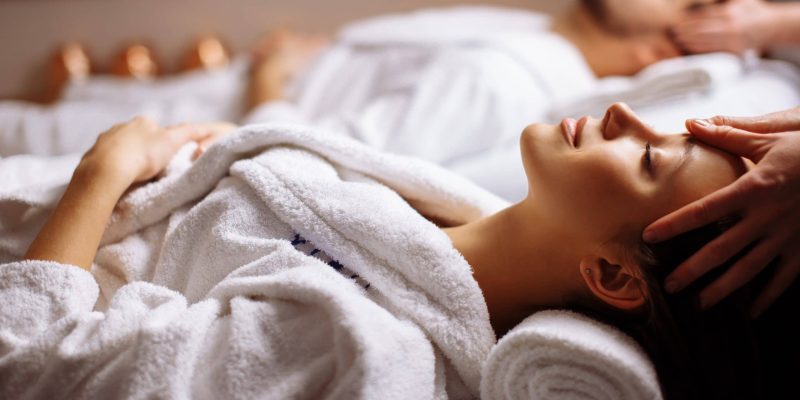 Young couple receiving head massage at beauty spa